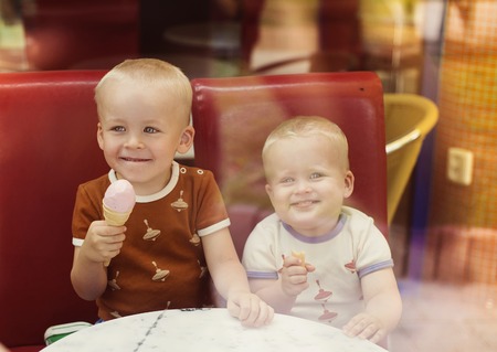 Little boys enjoying ice cream in cafeの写真素材