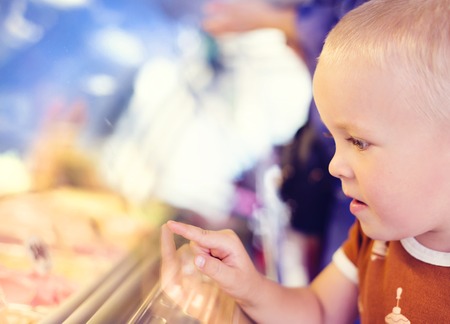 Little boy enjoying ice cream in cafeの写真素材