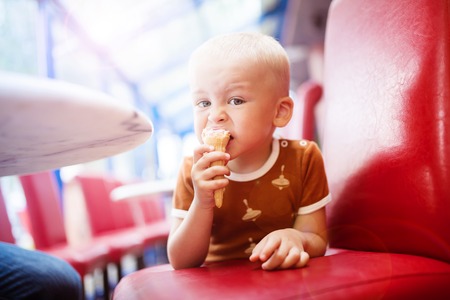 Little boy enjoying ice cream in cafeの写真素材