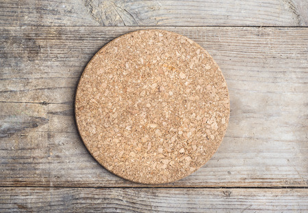 Round cork mat on wooden floor backgroundの写真素材