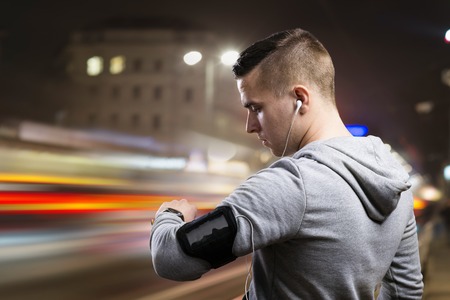 Young sportsman jogging in the night cityの写真素材