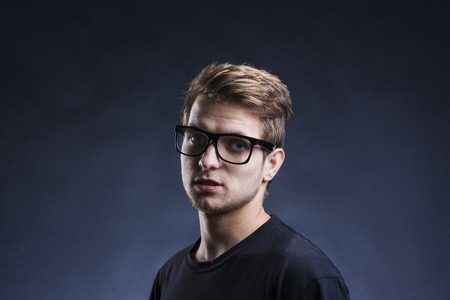 Stylish handsome young man posing. Studio shot on black background