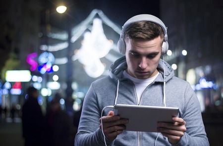 Young sportsman in the night city with a tabletの写真素材