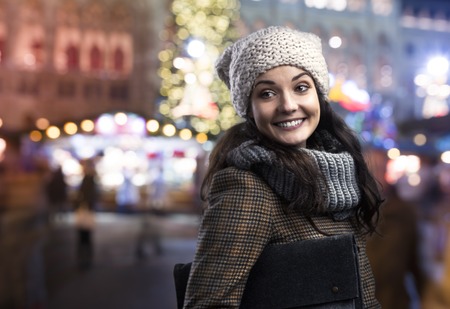Beautiful woman in warm clothing outside in the winter night cityの写真素材
