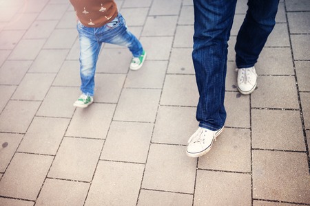 Unrecognizable cute little boy and his father on a walk in the cityの写真素材