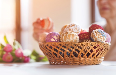 Unrecognizable senior woman with easter eggs and tulips.の写真素材