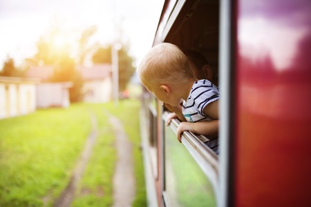 Little boy traveling in train looking outside the window.の写真素材