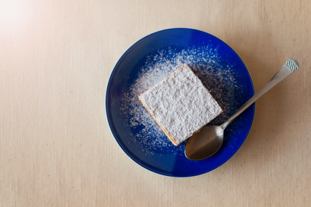 Piece of cake on a plate on white tablecloth background.の写真素材