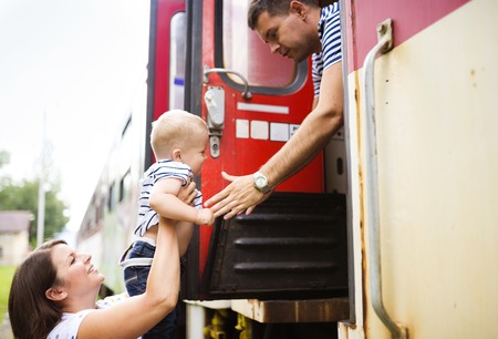 Family with a son travel entering the train.の写真素材