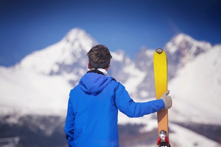 Young man skiing outside in sunny winter mountainsの写真素材