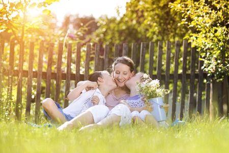 Happy mother with her children spending time together outside in green nature.の写真素材