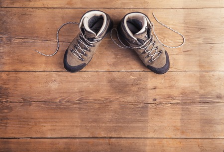 Hiking shoes laid on a wooden floor backgroundの写真素材