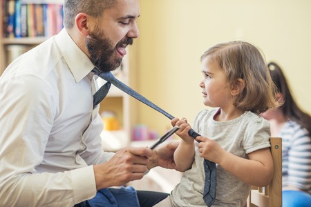 Young father getting his little daughter ready in a morningの写真素材