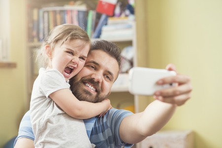 Young father with his cute little daughter taking selfie Young father with his cute little daughter taking selfie