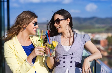 Two beautiful women having fun in a barの写真素材