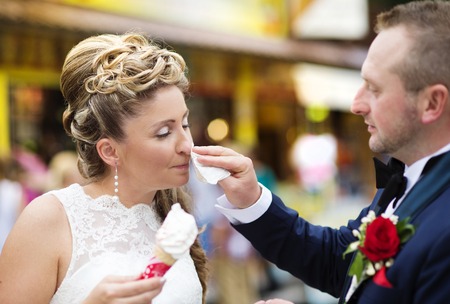 Beautiful young wedding couple enjoying ice creamの写真素材