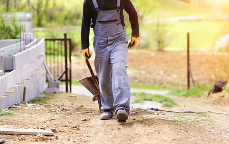 Unrecognizable bricklayer with an empty wheelbarrow walkingの写真素材