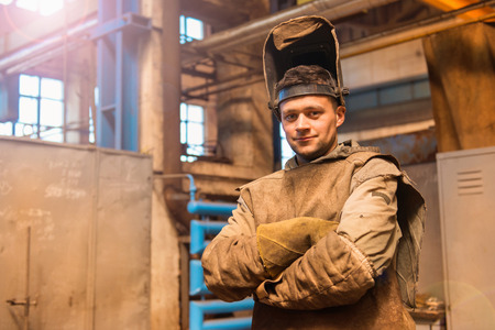 Young man in a factory in protective workwearの写真素材