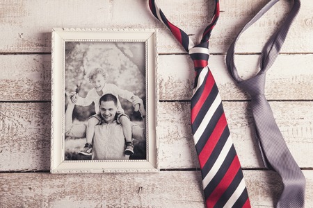 Picture frame with family photo and two ties laid on wooden .の写真素材
