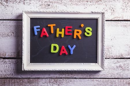 Picture frame with Fathers day sign laid on wooden floor .の写真素材