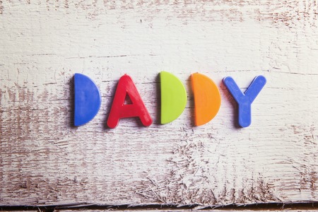 Colorful Daddy sign on a white wooden background.の写真素材