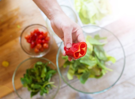 Unrecognizable man preparing ingredients for vegetable saladの写真素材