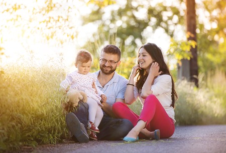 Happy young family having fun outside in spring natureの写真素材
