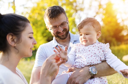 Happy young family having fun outside in spring natureの写真素材