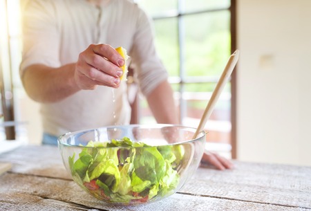 Unrecognizable man preparing ingredients for vegetable saladの写真素材