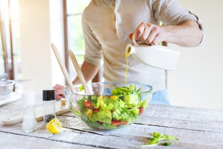 Unrecognizable man in the kitchen preparing healthy vegetable salad