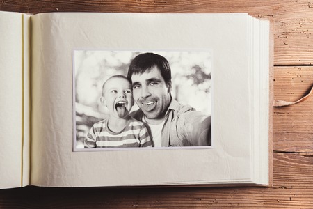 Fathers day composition - photo album with a black and white photo. Studio shot on wooden...
