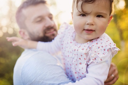 Happy young father with his daughter having fun outside in spring natureの写真素材