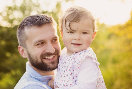 Happy young father with his daughter having fun outside in spring natureの写真素材