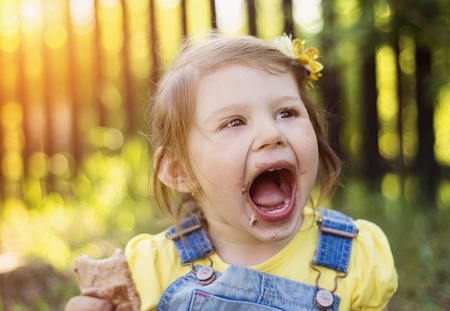 Cute little girl outside in nature on a sunny summer dayの写真素材