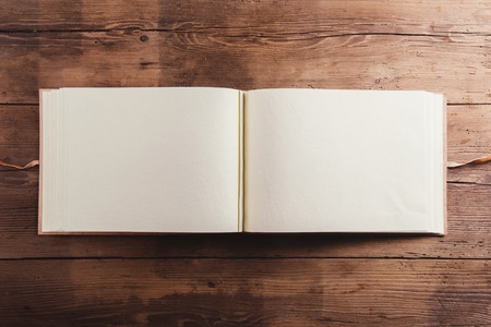 Photoalbum with an empty space for photos. Studio shot on wooden background.