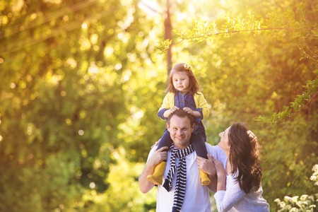 Happy young family spending time together outside in green natureの写真素材