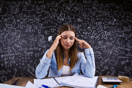 Beautiful girl studying in front of big blackboardの写真素材