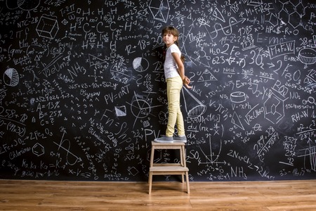 Cute little girl in front of big blackboardの写真素材