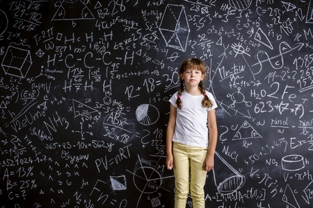 Cute little girl in front of big blackboard