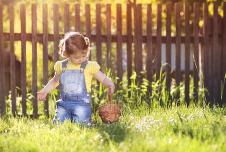 Cute little girl with chocolate face lying on a grassの写真素材