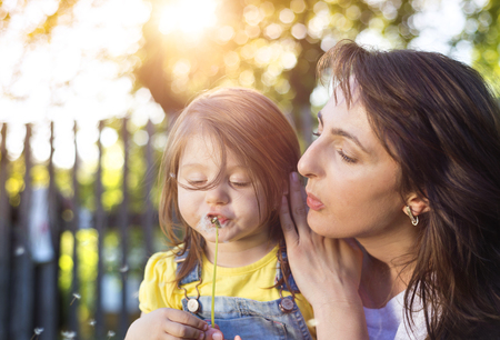 Happy mother and daughter outside in green natureの写真素材