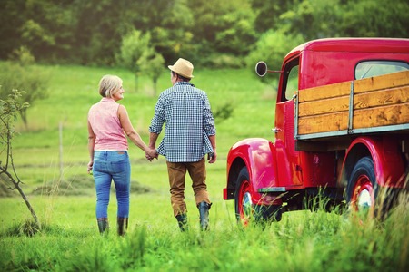 Senior couple walking by a red truckの写真素材