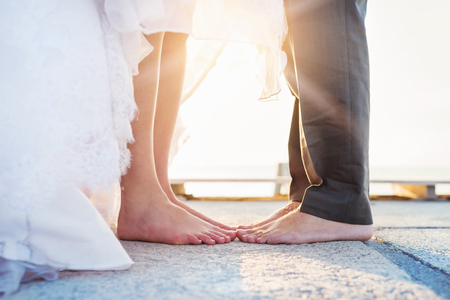 Feet of a bride and groom standing on the pierの写真素材
