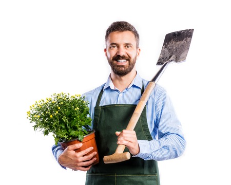 Young handsome gardener in green apron. Studio shot on white backgroundの写真素材