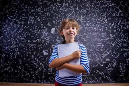 Cute little girl in front of big blackboardの写真素材
