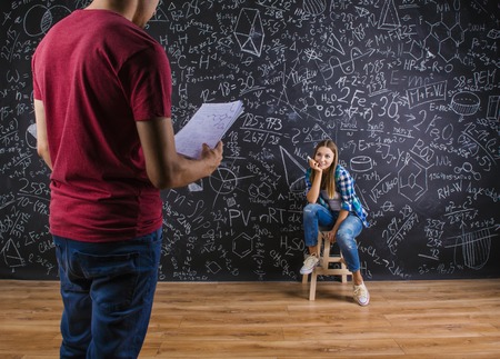 Beautiful young students in front of big blackboard