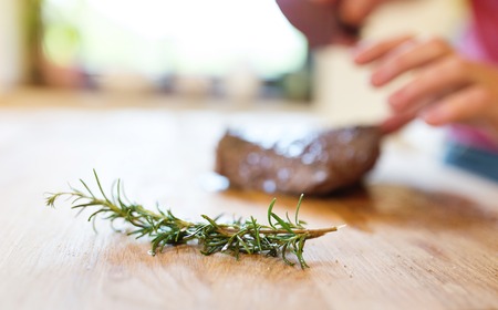 Man slicing a grilled beef stead on a wooden cutting boardの写真素材
