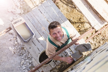 Mason putting decorative natural stones on a wallの写真素材