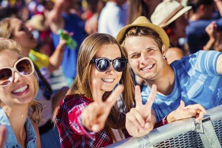 Group of beautiful teens at concert at summer festival