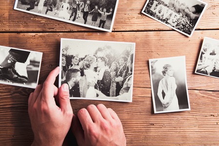 Wedding photos laid on a table. Studio shot on wooden background.の写真素材